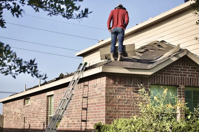 Professional roofer working on a residential roof in Ault